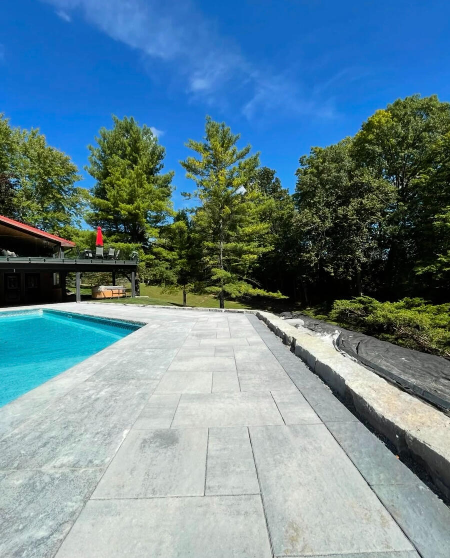 Straight interlock pool walkway with armour stone border in Durham.