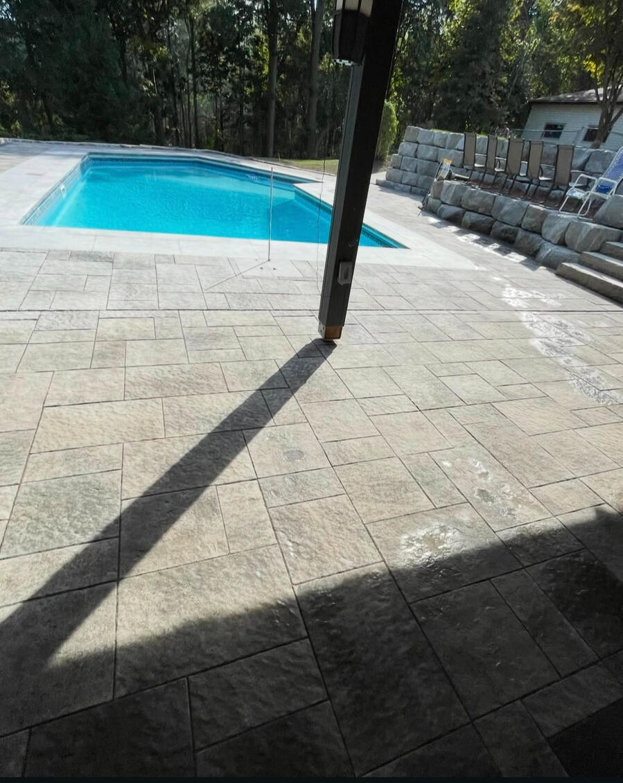 Covered patio looking over an interlock pool deck in Durham.