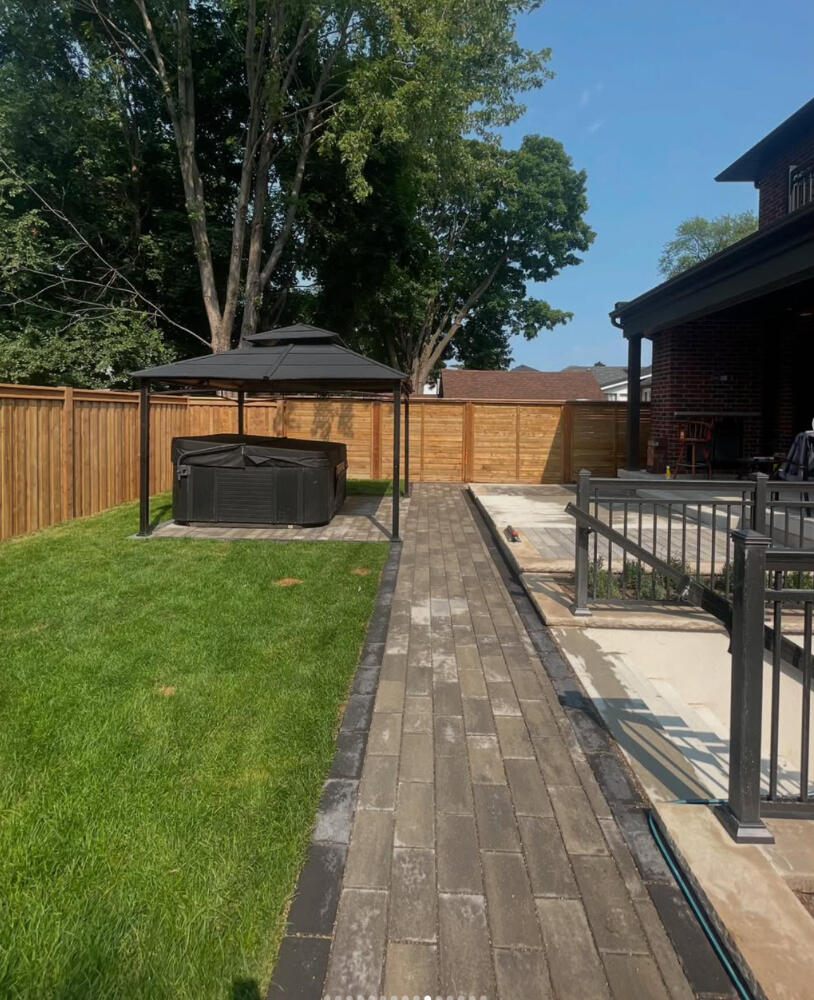 Interlock walkway and pad leading to gazebo and hot tub.